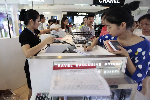 Tourists select products at a duty free shop (DFS) in Sanya, south China's tourist destination Hainan Province, April 23, 2014. (Photo/Xinhua)