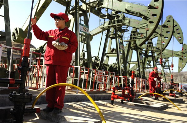 A worker checks facilities of Shaanxi Yanchang Petroleum (Group) Co in Wuqi county, Shaanxi province.(Photo/Xinhua)