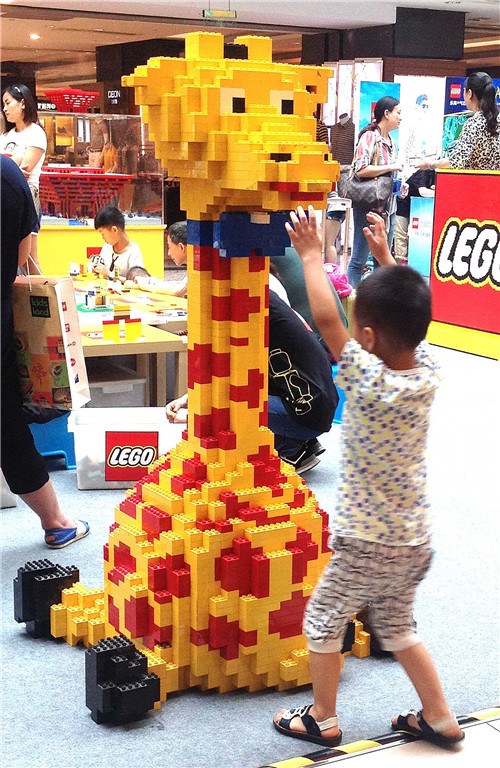 A boy plays with giraffe-shaped Lego bricks at a toy fair in Hangzhou, Zhejiang province. Photo: China Daily/Zhu Yinwen)