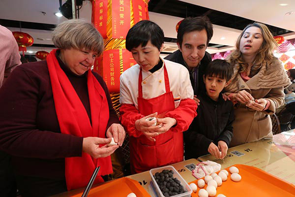 Foreign residents learn how to make sweet dumplings, a traditional treat for Chinese Lantern Festival, in Shanghai. (Photo/China Daily)