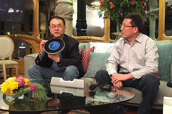 Wu Wenliang, left, co-founder and senior vice president of Beijing Shu Zi Jia Yuan Technology Ltd, and Tang Bo, founder and CEO of the company, demonstrate the QLove Phone, Feb 23, 2016. (Liu Zheng/chinadaily.com.cn)