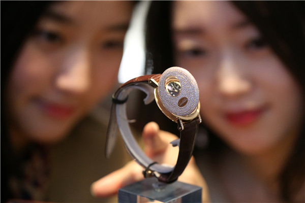 Two women inspect a Breguet wrist watch inlaid with 706 diamonds, and priced 1.77 million yuan ($276,563).CHINA DAILY
