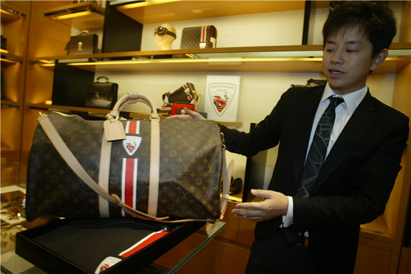 A salesman shows a special Panda logo on a Louis Vuitton handbag in a LV boutique in Dalian.CHINA DAILY