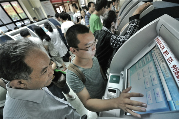 People use registration machines with their bank debit cards at the registration center of Peking Union Medical College Hospital. CHINA DAILY