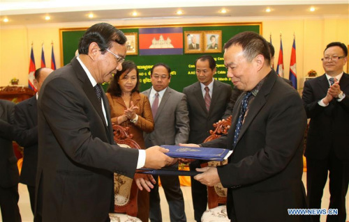 Cambodian Minister of Posts and Telecommunications Prak Sokhonn (L) exchanges documents with Huang Xinglong, chairman of the Cambodia Fiber Optic Communication Network (CFOCN), during a signing ceremony in Phnom Penh, Cambodia, March 2, 2016. Photo: Xinhua/Sovannara)