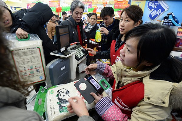 A consumer pays via a digital payment system in a supermaket in Wuhan, capital of Hubei province. (Photo/China Daily)