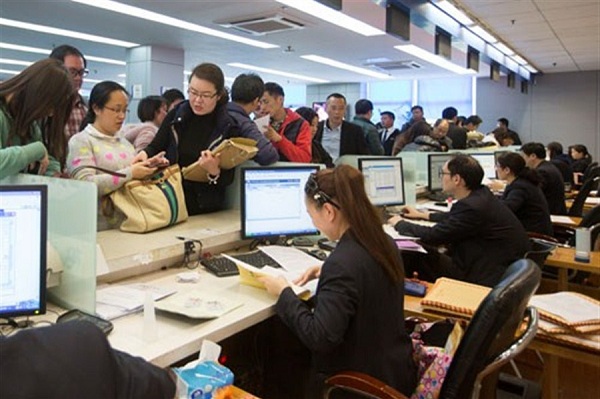 Home buyers line up in front of the deed tax collection counter to go through their purchase procedures over the weekend at the crowded housing transaction center in Shanghais Minhang District. Even as home prices climb, buyer interest has heated up, fueled perhaps by fears that waiting will mean even higher prices.(Zhu Weihui)