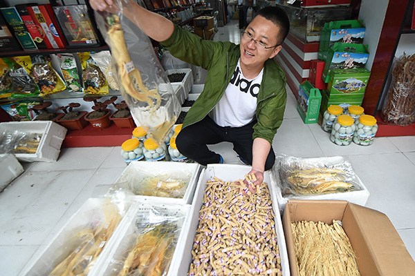 Businessman Sun Hui shows ginseng products at his shop in Ji'an, Jilin province, a major area for ginseng growth, where the annual production of fresh ginseng has reached 4,000 metric tons. (Photo/Xinhua)