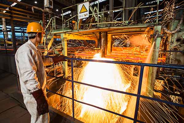 A worker at a steel company in Lianyungang, Jiangsu province, in January 2015. The steel sector will reduce capacity by 100 to 150 million metric tons in five years, according to China's top economic planner.(Photo by Si Wei/China Daily)