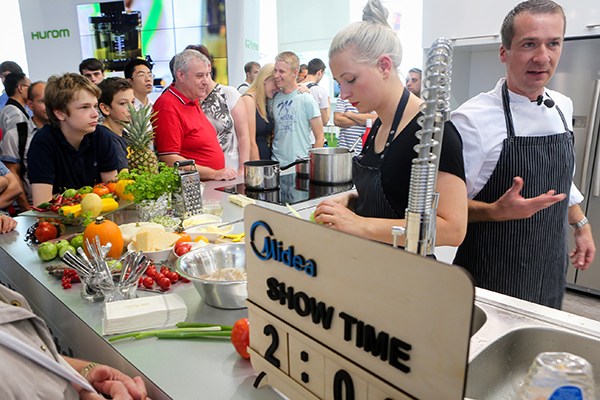 Staff from Midea Group show how its smart kitchen works at an international electric home appliance expo in Berlin, Germany. (Photo/Xinhua)