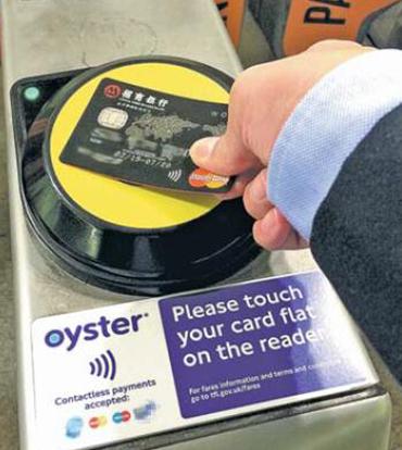 A passenger swaps a China Merchants Bank card supported by global payments company MasterCard to purchase a ride on a London subway. With rapid urbanization in China, MasterCard wants to help build smart cities in the country. (Photo provided to China Daily)