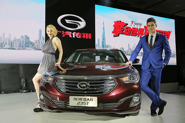 Models pose for a photo with the newly introduced version of the GA6, a homegrown car produced by Guangzhou-based GAC Motor, on Monday in Guangzhou, capital of Guangdong province. (Photo: China Daily/Qiu Quanlin)