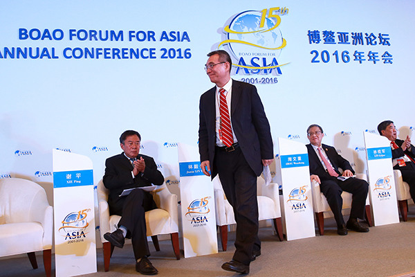 Justin Yifu Lin (standing), a professor of economics at Peking University and former World Bank chief economist, attends a news conference at the Boao Forum for Asia Annual Conference in Boao, Hainan province, on March 22, 2016. (Photo/China Daily)