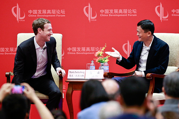Mark Zuckerberg, CEO of Facebook Inc, talks with Jack Ma, chairman of Alibaba Group Holding Ltd at the China Development Forum in Beijing on Saturday. (Photo/China Daily)