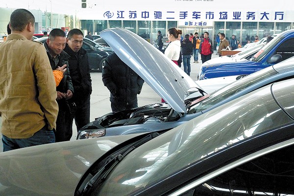 Visitors examine cars at an event for the trade of secondhand cars in Nanjing, Jiangsu province. New government policies and regulations are expected to spur sales of secondhand vehicles. (Photo/China Daily)