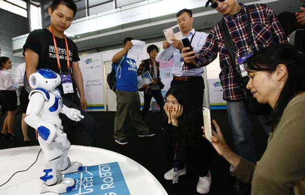 Visitors watch a robot dancing at the 2015 International Consumer Electronics Show (CES) Asia in Shanghai, May 27, 2015. (Photo/Xinhua)