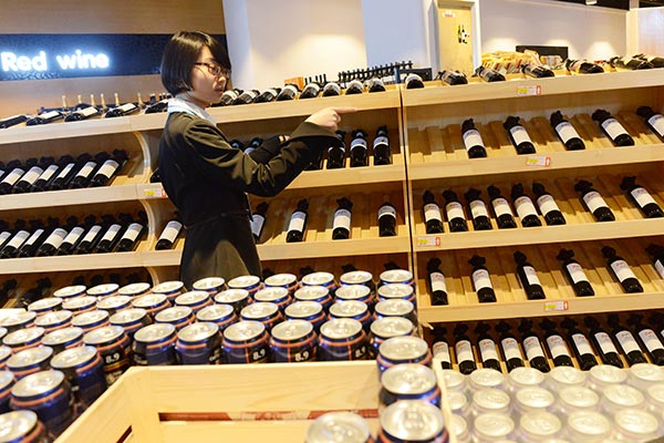A customer chooses wine at a cross-border duty-free shop at the Zhengzhou airport, Henan province. ZHANG TAO / FOR CHINA DAILY