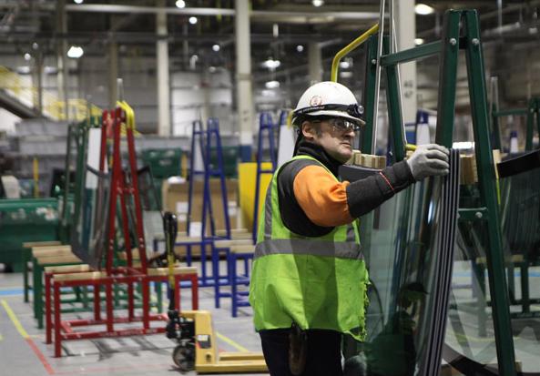 A worker inspects parts at Fuyao Glass America, the US branch of China's largest automotive glass maker. The company is working toward achieving full production capacity at its facility in Moraine, Ohio. HEZI JIANG / CHINA DAILY