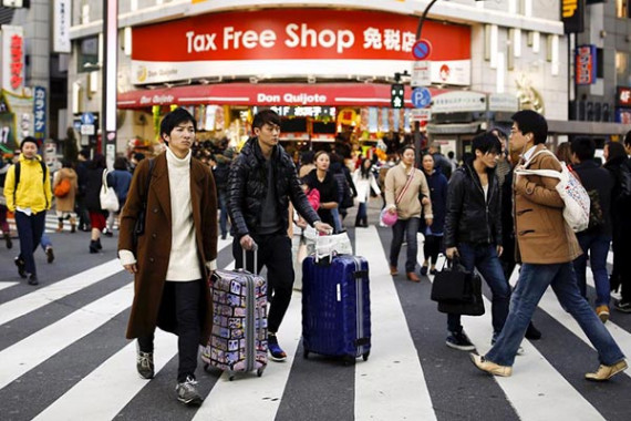People cross a street outside a tax free department store popular among Chinese tourists in Tokyo, Japan, February 11, 2016. (Photo/China Daily)