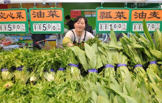 A vegetable vendor organizes her products inside a supermarket in Cangzhou City, north China's Hebei Province, April 10, 2016. China's Consumer Price Index (CPI) saw a 2.3% year-on-year increase in March, same as in February, official data showed Monday. (Xinhua/Mou Yu)