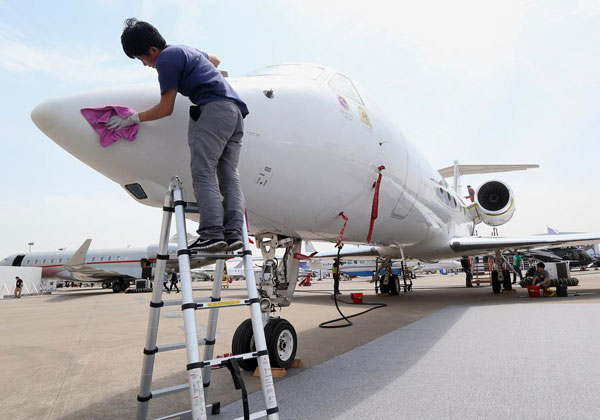 A worker cleans a plane taking part in the Asian Business Aviation Conference and Exhibition 2016, which runs from April 12 to 14 at Shanghai's Hongqiao Airport, on April 11, 2016. (Photo/Xinhua)