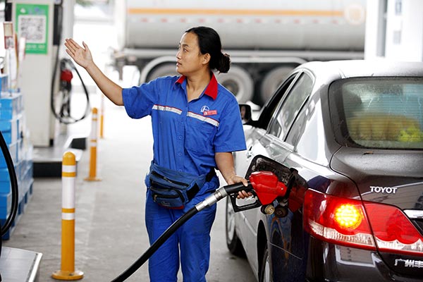 A worker fills up a car with fuel at a gas station in Huaibei city, East China's Anhui province, Sept 2, 2015. Xie Zhengyi / for China Daily