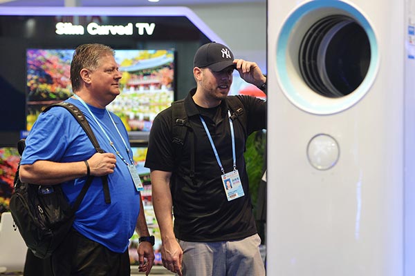 Two foreign visitors to the ongoing China Import and Export Fair, held in Guangzhou, Guangdong province, look at electronics on display. LIN GUIYAN / FOR CHINA DAILY