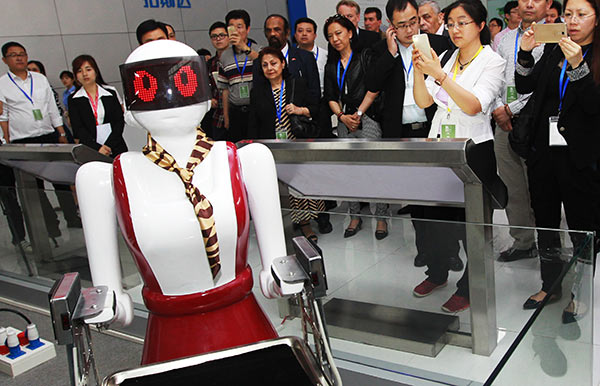 Foreign diplomats and business executives visit a robotics company in Dongguan, Guangdong province, on Wednesday. (Provided To China Daily)