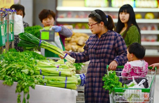 A woman chooses vegetables inside a supermarket in Baoding City, north China's Hebei Province, April 10, 2016. China's Consumer Price Index (CPI) saw a 2.3% year-on-year increase in March, same as in February, official data showed Monday. (Photo: Xinhua/Zhu Xudong)