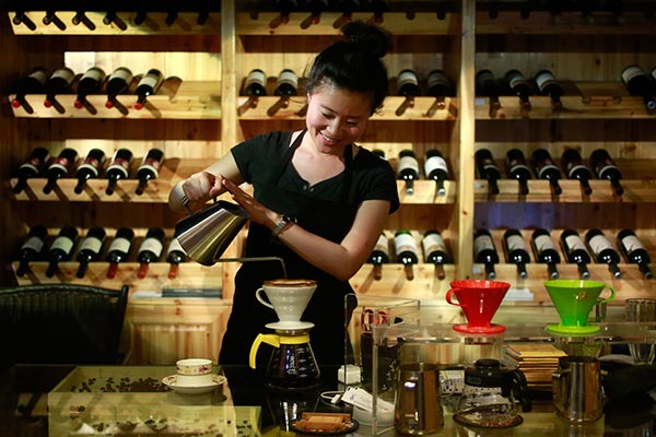 A woman makes coffee in a coffee shop in Pu'er, Yunnan province, a major coffee growing area in China. FENG YONGBIN / CHINA DAILY