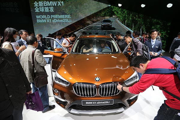 Visitors inspect the BMW X1 at the ongoing Beijing auto show. WANG ZHUANGFEI / CHINA DAILY