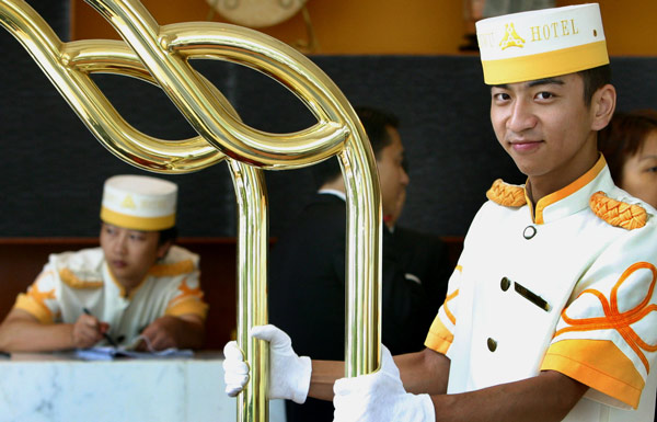 A bellboy helps guests carry their luggage in a star hotel in Nanjing, Jiangsu Province.(Photo/China Daily)