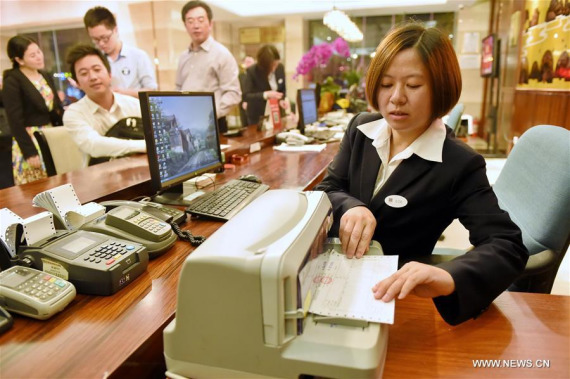 A staff member prepares a value-added tax (VAT) invoice for guest at Fuzhou Hotel in Fuzhou, capital of southeast China's Fujian Province, May 1, 2016. (Photo: Xinhua/Li Shanchuan)
