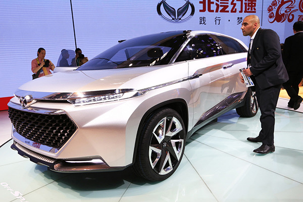 A visitor to the 2016 Beijing International Auto Expo, which was held last month, examines a new-energy vehicle made by Beijing Automotive Industry Holding Co. (Photo/Xinhua)