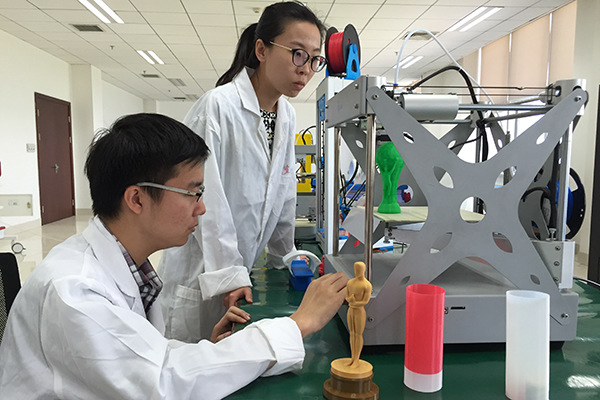 Two engineers at the Tianjin Jinhang Physics Research Institute under China Aerospace Science and Industry Corp conduct test on a 3-D printer.(Photo provided to China Daily)