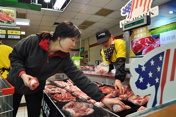 A consumer chooses pork imported from the United States at a supermarket in Zhengzhou, capital of Henan province. (Photo provided to China Daily)