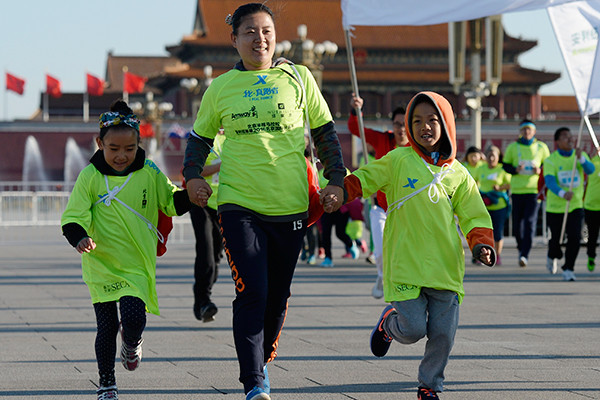 A mother and her two children join an international running festival in Beijing. The event attracted more than 20,000 participants. (Photo/China Daily)