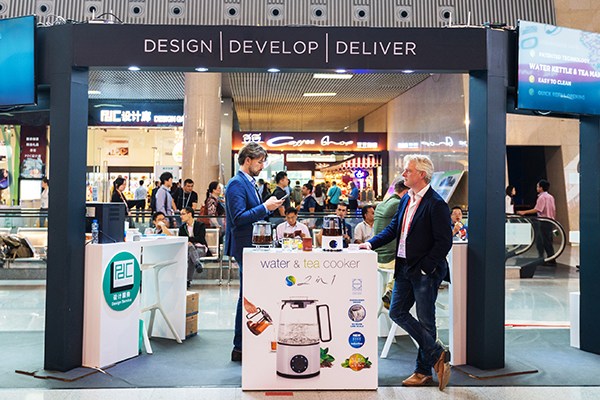 Two exhibitors stand by their small smart home appliance booth at the Canton Fair in Guangzhou, Guangdong province. The ongoing fair attracts 25,000 enterprises from home and abroad. (Photo/China Daily)