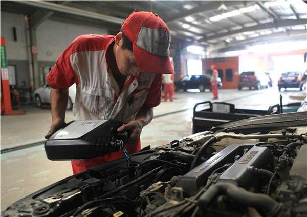 A technician at a 4s dealership in Pingdingshan, Henan province, works on a car. HE JINWEN/CHINA DAILY