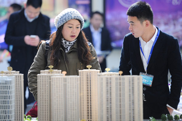 A woman talks with a salesman at a property market fair in Hangzhou, Zhejiang province.Photo/China Daily