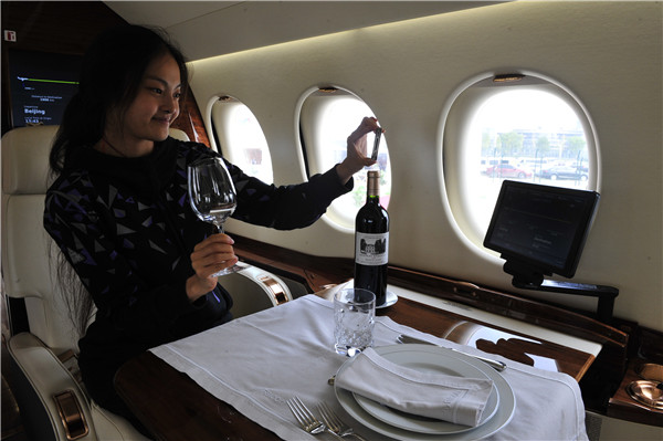 A woman tries out a Dassault Falcon 7X model at a business jets show in Beijing last year.WANG WEI/CHINA DAILY