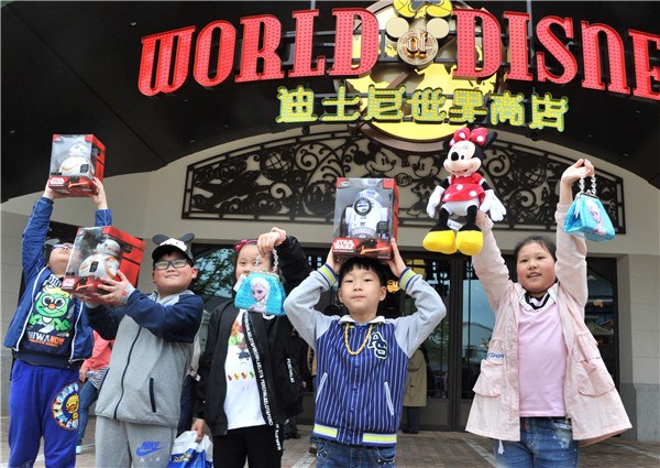 Children flaunt their newly bought gifts at the Disney store, the biggest park-operated retail shop in Asia, in Shanghai over the weekend.(YANG YI/CHINA DAILY)