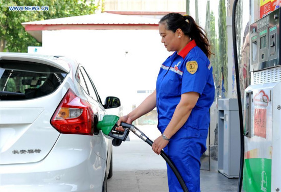 A worker at a gas station fills the tank of a vehicle in Guangzong County, north China's Hebei Province, May 11, 2016. (Photo: Xinhua/Zhu Xudong)