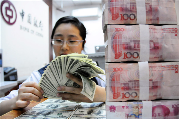 A clerk of Bank of China counts US dollars at a domestic branch.(Photo/Xinhua)