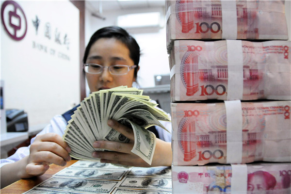 A clerk of Bank of China counts US dollars at a domestic branch.(Photo/Xinhua)