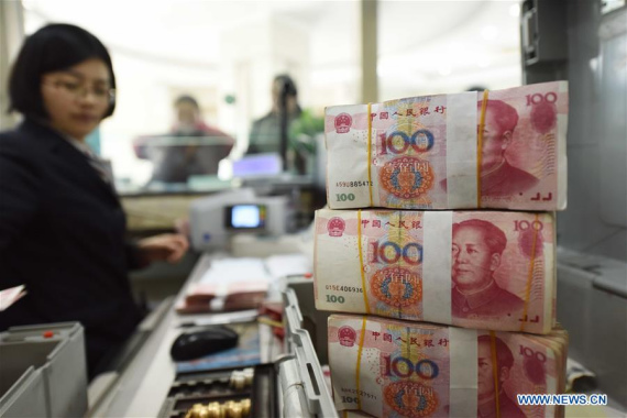 A bank staff member checks RMB banknotes at a bank in Lianyungang, east China's Jiangsu Province, Jan. 7, 2016. (Xinhua file photo/Si Wei)