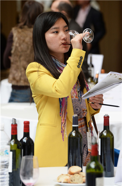 A woman tastes a 2013 vintage red wine at the Palais de la Bourse in Bordeaux, southeastern France. Bordeaux's exports to China rebounded recently, after the region adjusted the structure of its supplies.(CHINA DAILY)