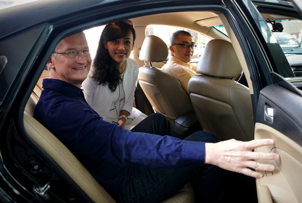 Apple CEO Tim Cook takes a Didi taxi with Jean Liu Qing, president of Didi, to an Apple store in Wangfujing in downtown Beijing on Monday. Cook's visit follows Apple's investment of $1 billion in the Chinese ride-hailing service. PROVIDED BY WEIBO OF TIM COOK