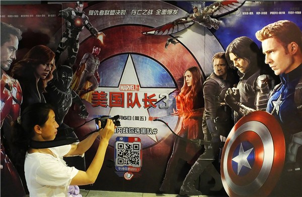 A cinema goer takes a picture of the Captain America 3 poster in Yichang, Hubei province. CHINA DAILY