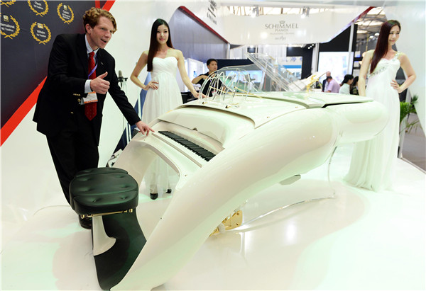 A German exhibitor introduces a Schimmel piano at an expo in Shanghai.(LAI XINLIN/CHINA DAILY)